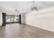 Spacious living room featuring wood-look tile flooring, stylish light fixture, and ceiling fan at 6847 Sperone St, Orlando, FL 32819