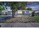 Charming single-story home featuring a well-maintained front yard and a classic exterior design at sunset at 73 Garrison Ln, Frostproof, FL 33843