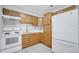 Efficient kitchen layout with light wood cabinets, white appliances, and tile flooring at 73 Garrison Ln, Frostproof, FL 33843