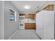 Bright kitchen features white appliances, wood cabinets, and a window for natural light at 73 Garrison Ln, Frostproof, FL 33843