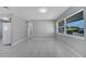 Bright living room featuring neutral paint, tile flooring, and natural light from a large window at 73 Garrison Ln, Frostproof, FL 33843