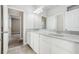 Bathroom with double vanity, white cabinets, and a view to the bedroom at 8433 Corkfield Ave, Orlando, FL 32832
