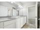 Bright bathroom featuring a double vanity, white cabinets, and neutral tiling at 8433 Corkfield Ave, Orlando, FL 32832