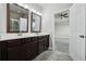 Bathroom with double sink vanity, framed mirrors, and tile flooring at 8433 Corkfield Ave, Orlando, FL 32832