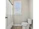 Bathroom with a toilet, shower curtain, and a window at 8433 Corkfield Ave, Orlando, FL 32832