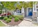 Inviting front porch with stone accents, a bright blue door, and manicured landscaping at 8433 Corkfield Ave, Orlando, FL 32832