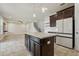 Open-concept kitchen with an island, stainless steel fridge, and seamlessly connected to living space at 8433 Corkfield Ave, Orlando, FL 32832