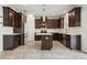 Spacious kitchen featuring dark wood cabinetry, stainless steel appliances, and a center island at 8433 Corkfield Ave, Orlando, FL 32832