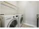 Bright laundry room with new washer and dryer, overhead shelving, and neutral walls at 8433 Corkfield Ave, Orlando, FL 32832