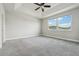 Bright main bedroom featuring tray ceiling, ceiling fan, plush carpet flooring and several windows with nice views at 8433 Corkfield Ave, Orlando, FL 32832