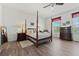 Traditional main bedroom with a canopy bed, wood floors, and natural light from the bright window at 848 Jadestone Cir, Orlando, FL 32828