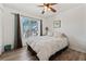 Cozy bedroom features a ceiling fan, hardwood floors, and a large window with plenty of sunlight at 848 Jadestone Cir, Orlando, FL 32828