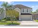 Charming two-story home featuring a two-car garage, well-manicured lawn, and mature landscaping at 848 Jadestone Cir, Orlando, FL 32828