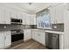 Modern kitchen features stainless steel appliances, white cabinets, and stone countertops at 848 Jadestone Cir, Orlando, FL 32828