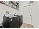 Functional laundry room with modern black washer and dryer, shelving and tile flooring at 848 Jadestone Cir, Orlando, FL 32828