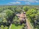 Expansive aerial view of the house surrounded by lush greenery, mature trees, and featuring a pool and brick driveway at 851 Georgia Ave, Winter Park, FL 32789