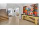 Elegant foyer showcasing wood floors, arched doorways, a staircase, and a stylish console table with vibrant artwork at 851 Georgia Ave, Winter Park, FL 32789