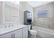 Bright bathroom featuring a tub with gray tiling, white vanity with plenty of storage and updated fixtures at 8520 Rose Groves Rd, Orlando, FL 32818