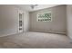 Neutral bedroom with carpet, a window, and a glass panel door at 8520 Rose Groves Rd, Orlando, FL 32818