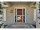 A closer look at the front door with a storm door and stone-look tiled porch at 8520 Rose Groves Rd, Orlando, FL 32818