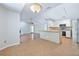 Open-concept kitchen boasts white cabinets, stainless steel appliances, and a breakfast bar at 8520 Rose Groves Rd, Orlando, FL 32818