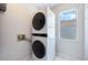 Laundry area showcasing a stacked washer and dryer, tile flooring, and a window for natural light at 8520 Rose Groves Rd, Orlando, FL 32818