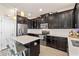 Bright kitchen featuring black cabinets, stainless steel appliances, an island with seating, and tile floors at 885 Carmillion Ct, Groveland, FL 34736