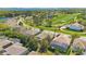 An aerial view showcases homes with screened-in pools, lush green landscaping, and a golf course with a lake at 10027 Hart Branch Cir, Orlando, FL 32832