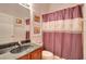 Bathroom featuring a marble countertop, dark wood vanity, decorative mirror, and a shower with a colorful curtain at 10027 Hart Branch Cir, Orlando, FL 32832