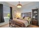 Cozy bedroom with a wooden bed frame, patterned bedding, and a window with natural light at 10027 Hart Branch Cir, Orlando, FL 32832