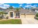 Charming single-story home with a well-manicured lawn, two car garage, and a palm tree in the front yard at 10027 Hart Branch Cir, Orlando, FL 32832