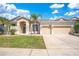 Home exterior displaying a three-car garage, manicured lawn, and well-maintained landscaping at 10027 Hart Branch Cir, Orlando, FL 32832