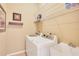 Functional laundry room with a washer, dryer, utility sink, and shelving for storage at 10027 Hart Branch Cir, Orlando, FL 32832