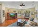 Inviting living room with hardwood floors, a ceiling fan, and sunlit windows offering backyard views at 10027 Hart Branch Cir, Orlando, FL 32832