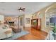 Open-concept living room with hardwood floors, a ceiling fan, and access to the kitchen and outdoor area at 10027 Hart Branch Cir, Orlando, FL 32832