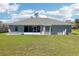 Rear exterior view of home featuring a screened-in porch and large backyard at 10367 Sw 45Th Ave, Ocala, FL 34476