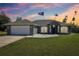 Beautiful home featuring an attached garage, arched windows, and manicured lawn at 10367 Sw 45Th Ave, Ocala, FL 34476