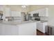 Well-lit kitchen with white cabinetry, stainless steel appliances, and an open layout with counter seating at 10367 Sw 45Th Ave, Ocala, FL 34476