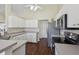 Modern kitchen with white cabinets, stainless steel appliances, and a view of the kitchen door at 10367 Sw 45Th Ave, Ocala, FL 34476