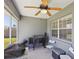 View of the screened-in patio with a ceiling fan, grill, chairs, and a window at 10367 Sw 45Th Ave, Ocala, FL 34476