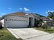 Lovely one-story home featuring a two-car garage, expansive driveway and manicured lawn with mature landscaping at 1352 Royal Saint George Dr, Orlando, FL 32828