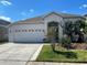 Charming one-story home with a two-car garage, well-maintained lawn and verdant tropical landscaping at 1352 Royal Saint George Dr, Orlando, FL 32828