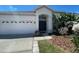 Attractive one-story home with a two-car garage, mature tropical landscaping and verdant grass at 1352 Royal Saint George Dr, Orlando, FL 32828