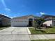Inviting one-story home with a two-car garage, well-maintained lawn and verdant tropical landscaping at 1352 Royal Saint George Dr, Orlando, FL 32828