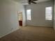 Bright main bedroom with two windows, ceiling fan, and bathroom entrance at 1352 Royal Saint George Dr, Orlando, FL 32828