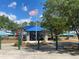Community playground featuring an American flag, blue canopies, and play structures at 1352 Royal Saint George Dr, Orlando, FL 32828