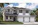 New two-story home featuring stone accents, a three-car garage, and professional landscaping at 1359 Wood Line Dr, Deland, FL 32720