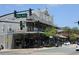 Exterior street view of building with shops, balconies, street lights, parked cars and trees against blue sky at 1359 Wood Line Dr, Deland, FL 32720
