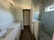 Elegant bathroom featuring dual sinks with quartz countertops and a glass-enclosed shower at 137 W G H Washington St, Apopka, FL 32703