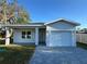 Charming single-story home featuring a one-car garage and a beautifully paved driveway and walkway at 137 W G H Washington St, Apopka, FL 32703